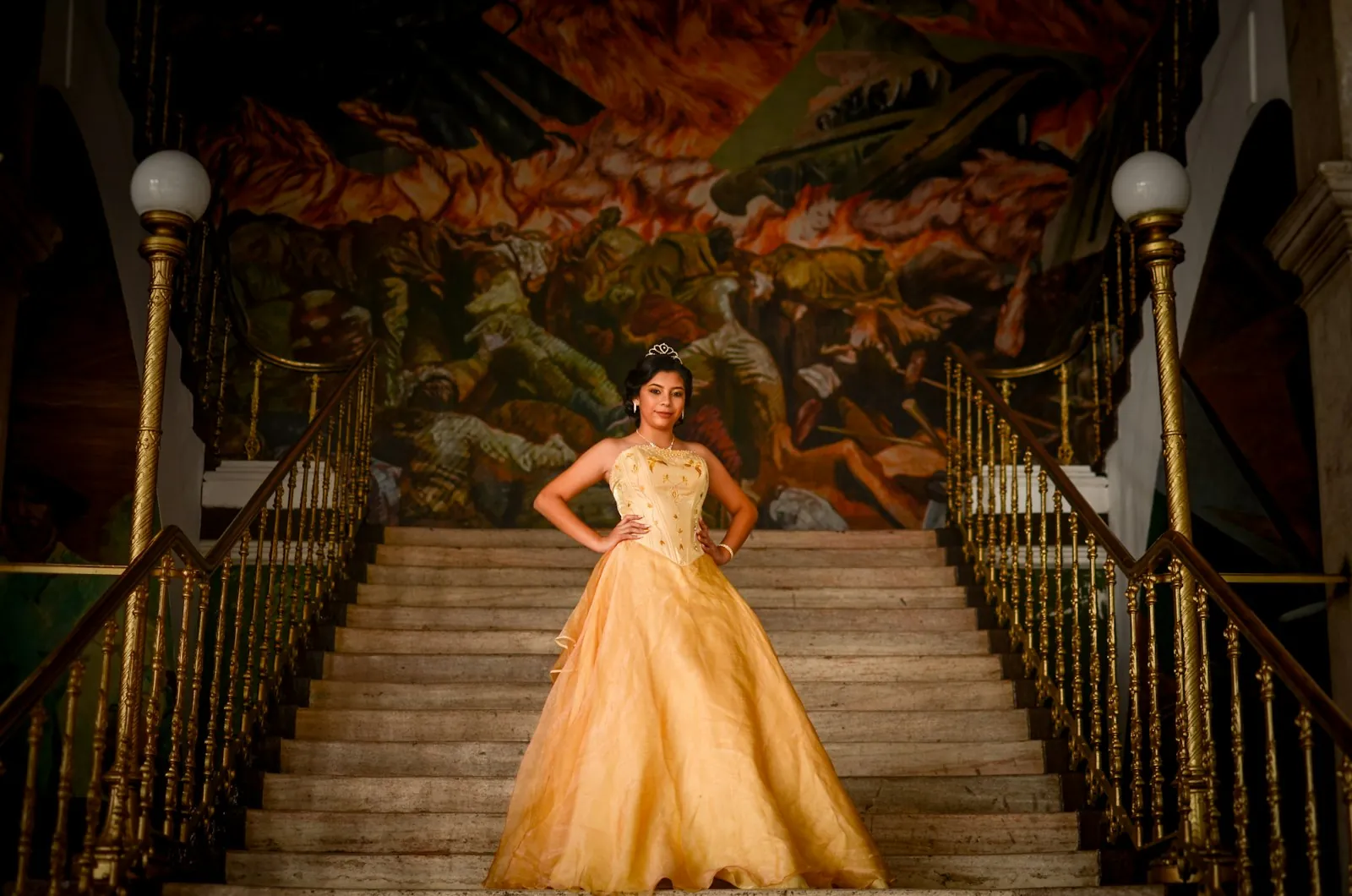 Robe de cérémonie dorée présentée en haut d'un grand escalier